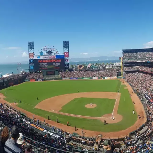 A view of San Francisco's Oracle Park looking out from the stands, 前景是棒球场，背景是贝博体彩app湾.